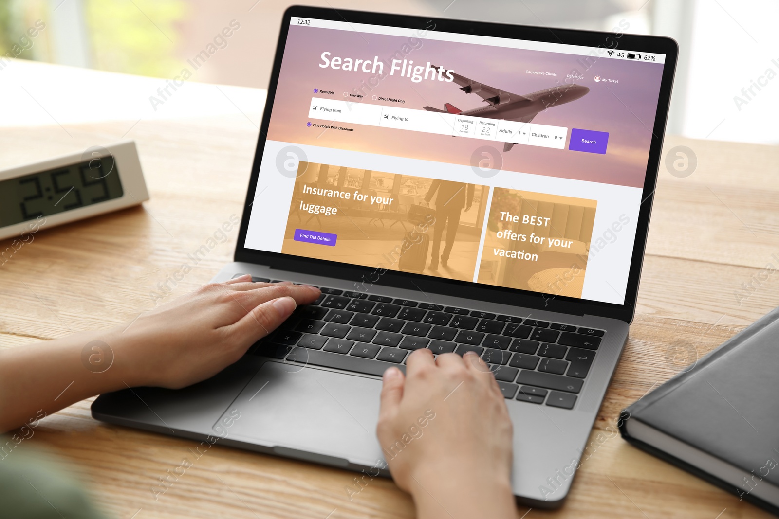 Image of Woman using laptop to book flight at wooden table, closeup