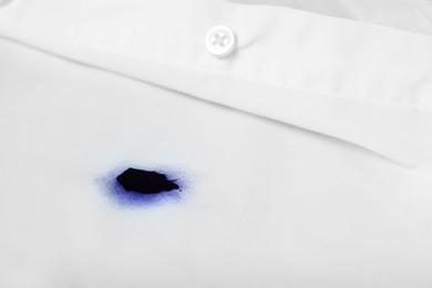 Photo of Stain of blue ink on white shirt, closeup. Space for text