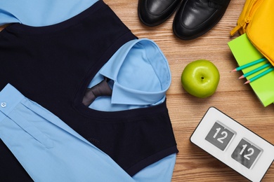 School uniform for boy and stationery on wooden background