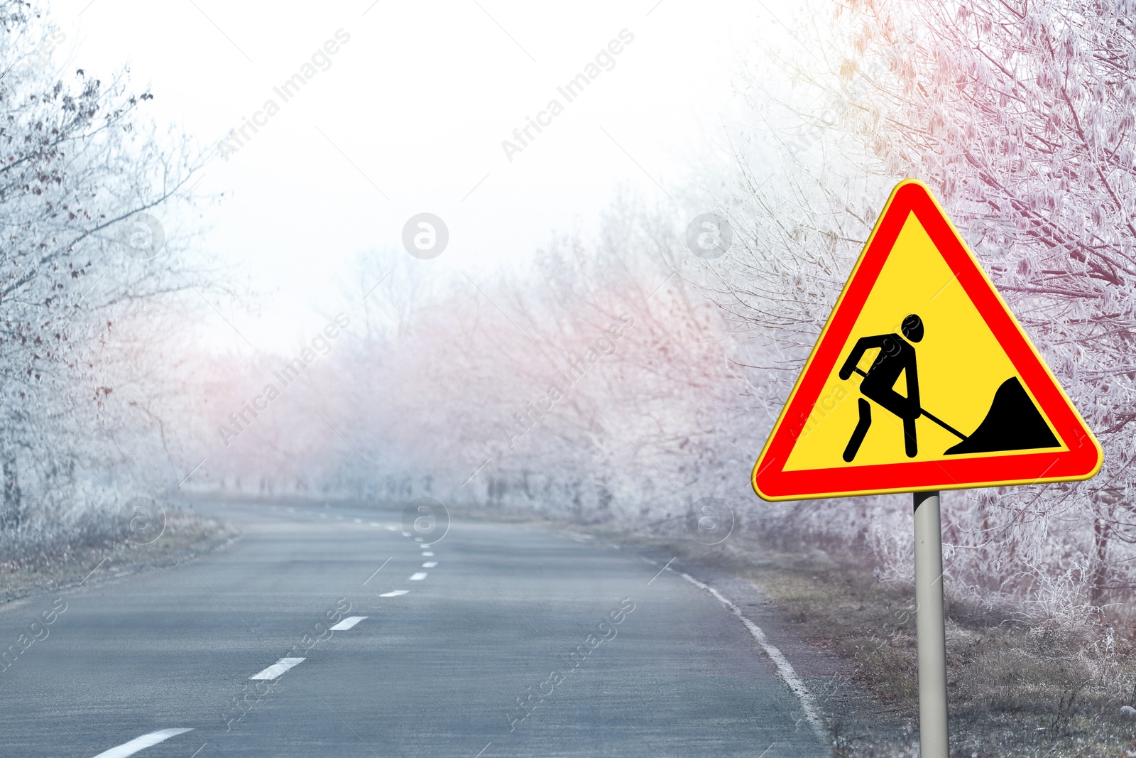 Image of Traffic sign Road Works near empty highway on winter day