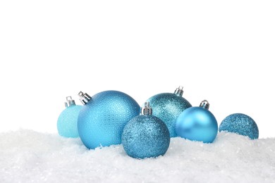 Photo of Beautiful light blue Christmas balls on snow against white background