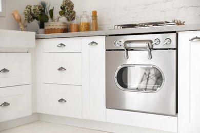 Photo of New modern oven in stylish kitchen. Cooking appliance