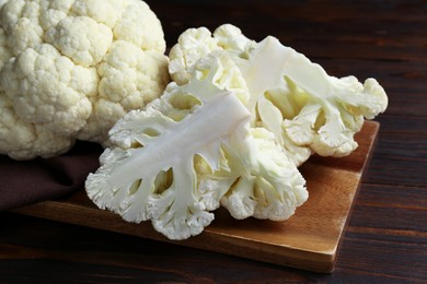 Photo of Fresh raw cauliflower on wooden table, closeup