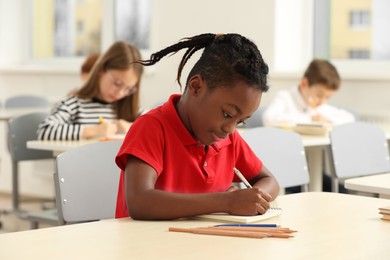 Photo of Portrait of cute little boy studying in classroom at school