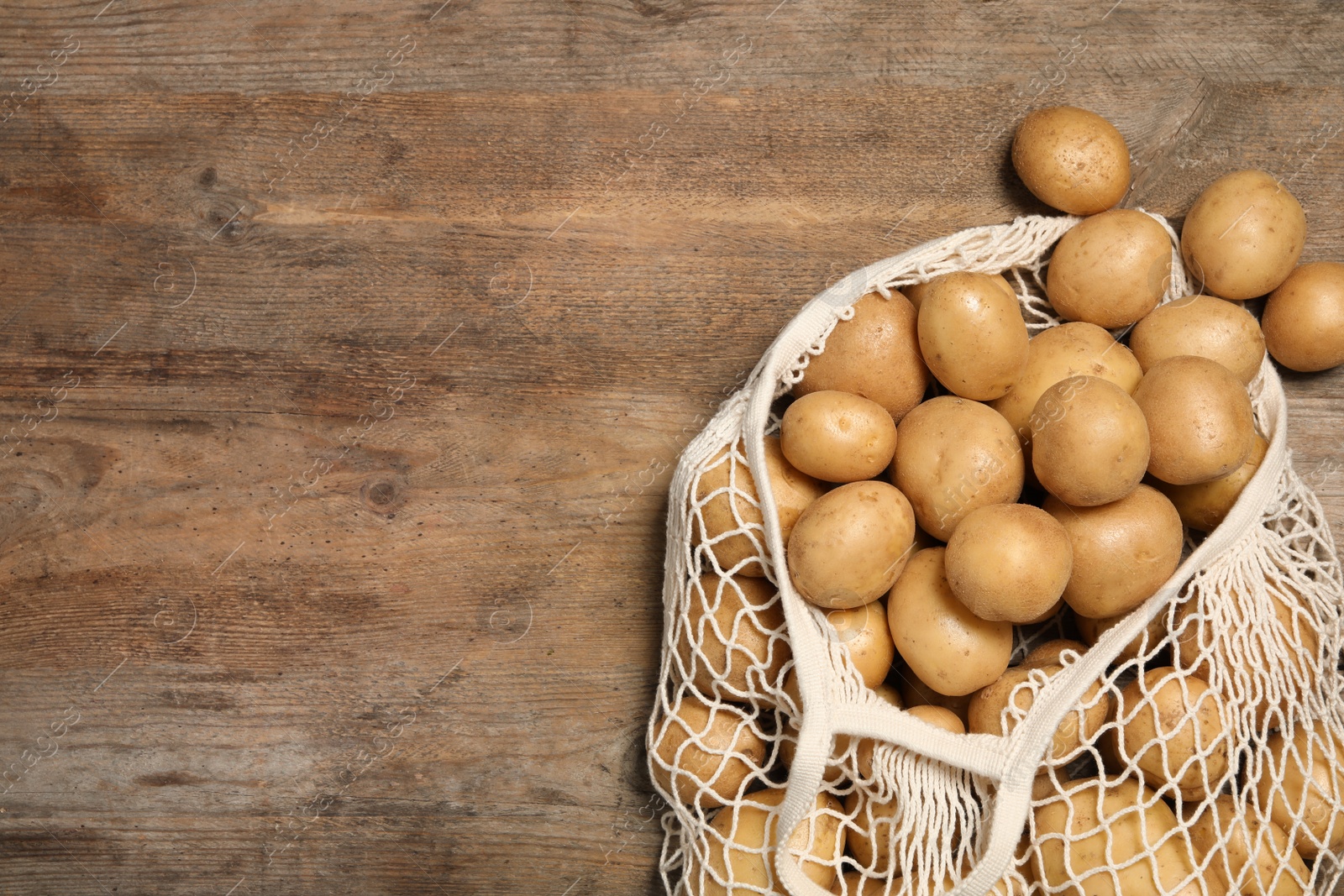 Photo of Raw fresh organic potatoes on wooden background, top view. Space for text