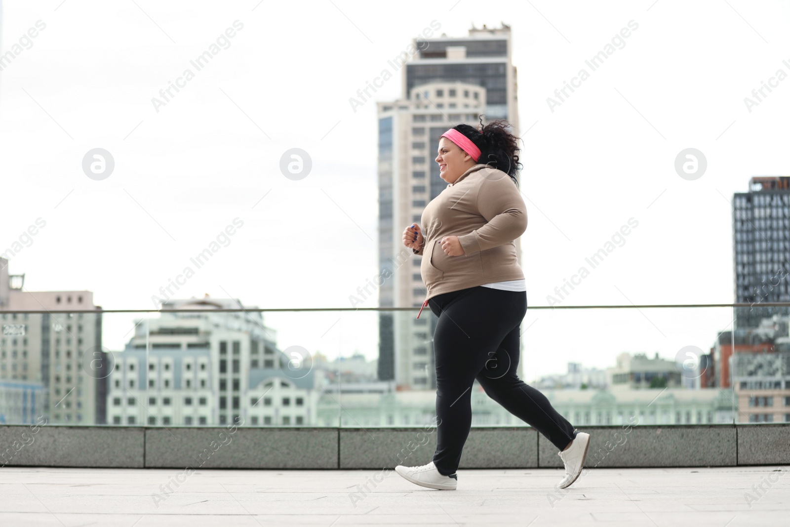 Photo of Beautiful overweight woman running outdoors. Fitness lifestyle