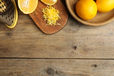 Photo of Lemon zest and fresh fruits on wooden table, flat lay. Space for text