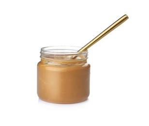 Jar and spoon with creamy peanut butter on white background