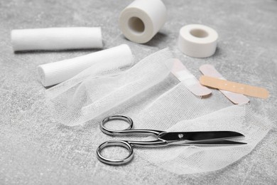 Photo of White bandage rolls and medical supplies on light grey table