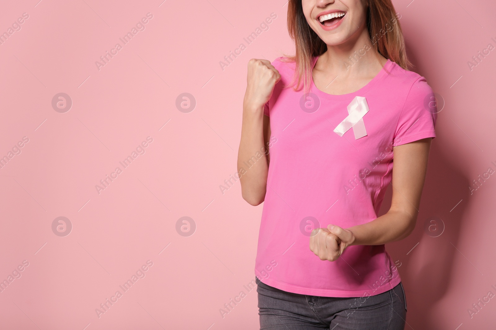 Photo of Woman wearing silk ribbon on color background, closeup with space for text. Breast cancer awareness concept