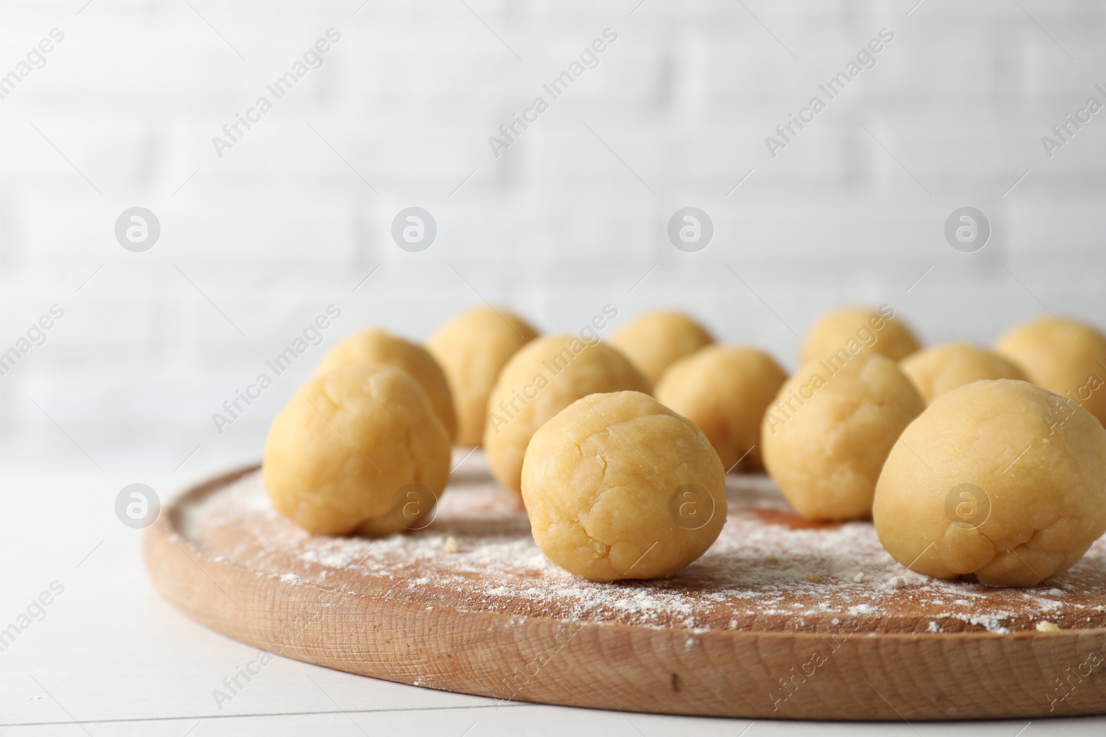 Photo of Shortcrust pastry. Raw dough balls on white wooden table, closeup