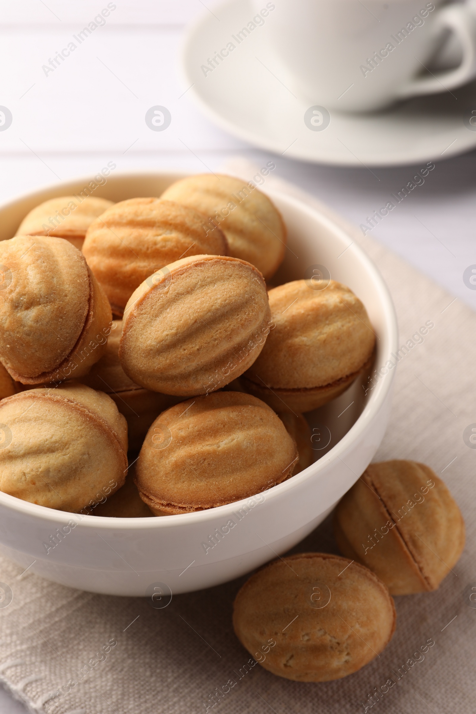 Photo of Delicious nut shaped cookies with boiled condensed milk on white wooden table