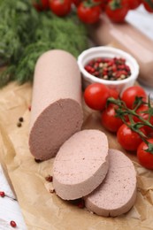 Delicious liver sausages and other products on white wooden table, closeup