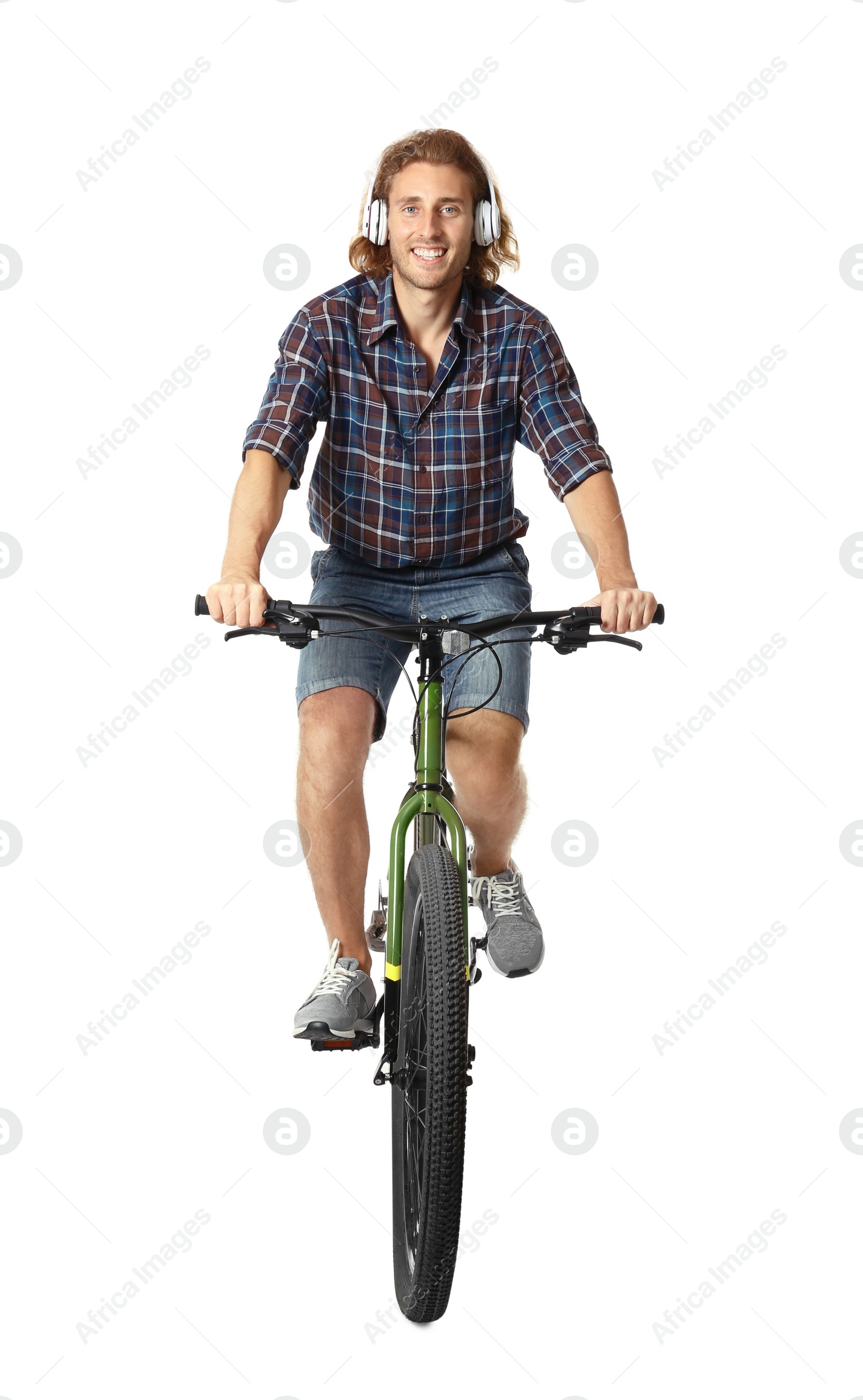 Photo of Happy young man with headphones riding bicycle on white background
