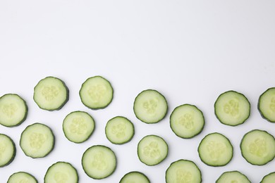 Fresh slices of cucumbers on white background, top view. Space for text