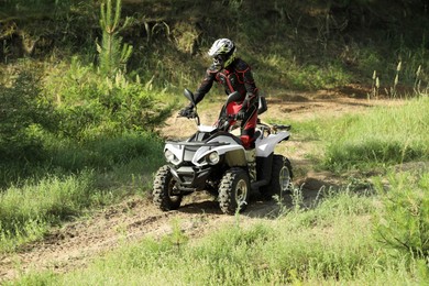 Photo of Man driving modern quad bike on sandy road. Extreme sport