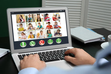 Teacher giving online school lesson during quarantine and social distancing due to Covid-19 pandemic, closeup. Pupils studying at home via video conference