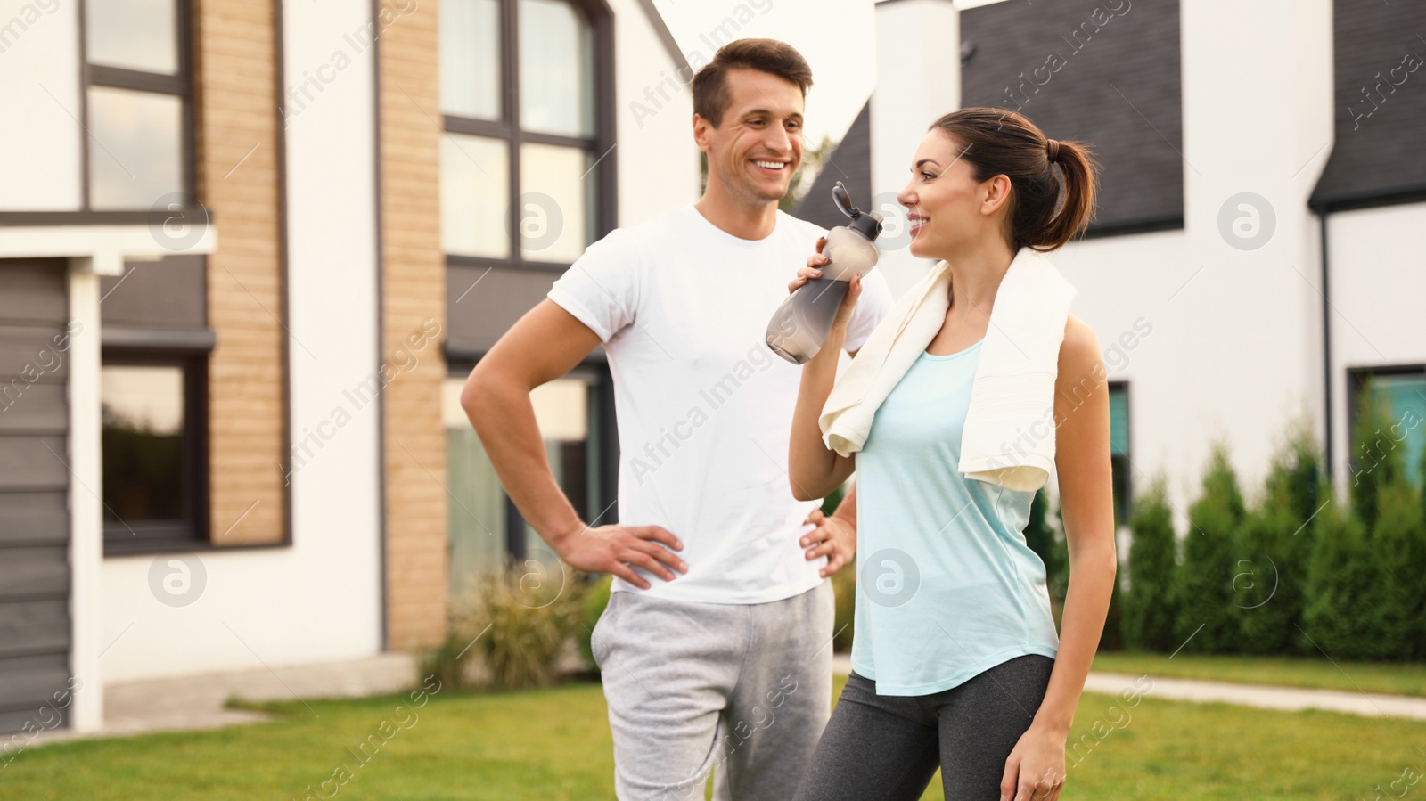 Photo of Sporty young couple on backyard after morning exercises. Healthy lifestyle
