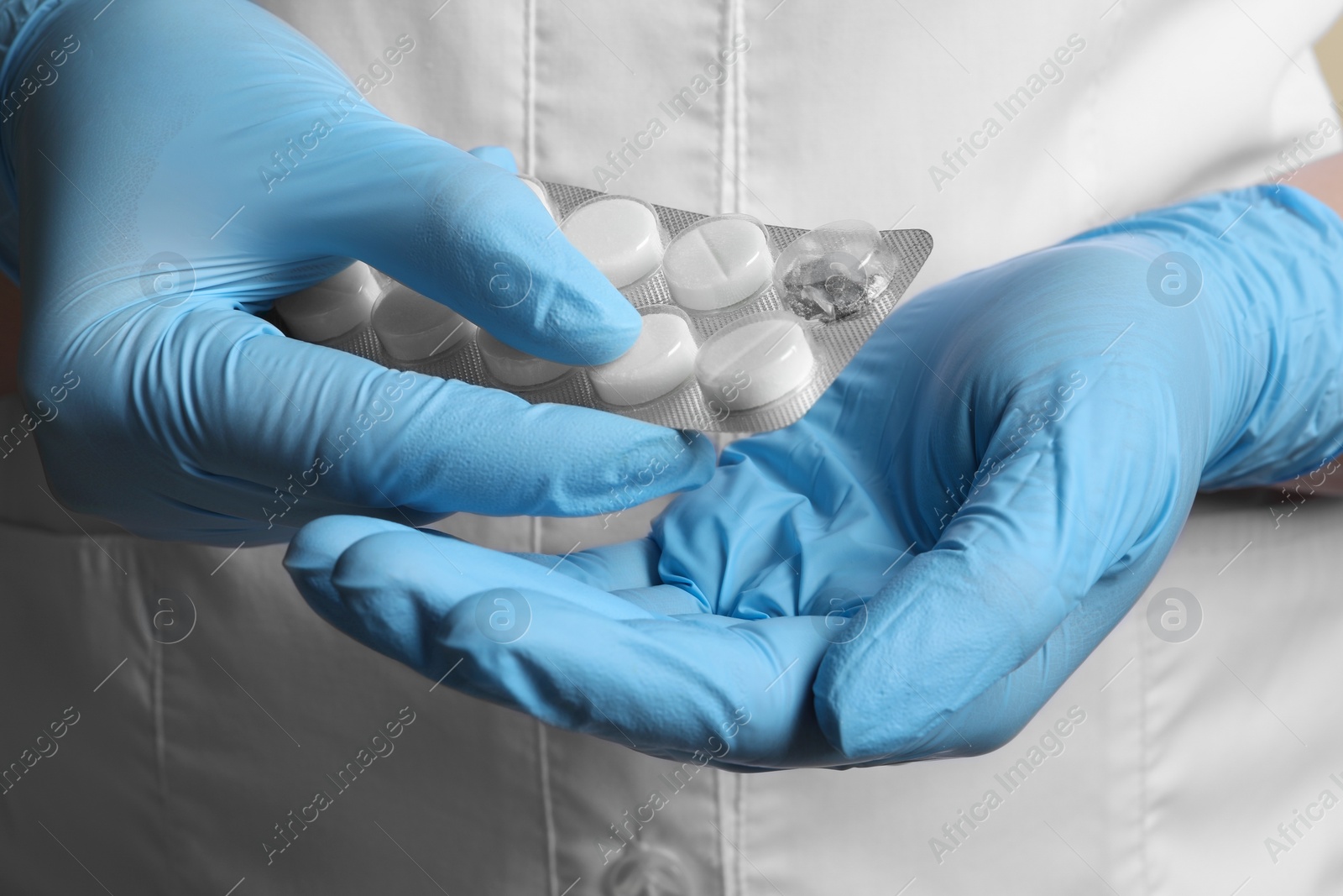 Photo of Doctor taking pill out from blister pack, closeup