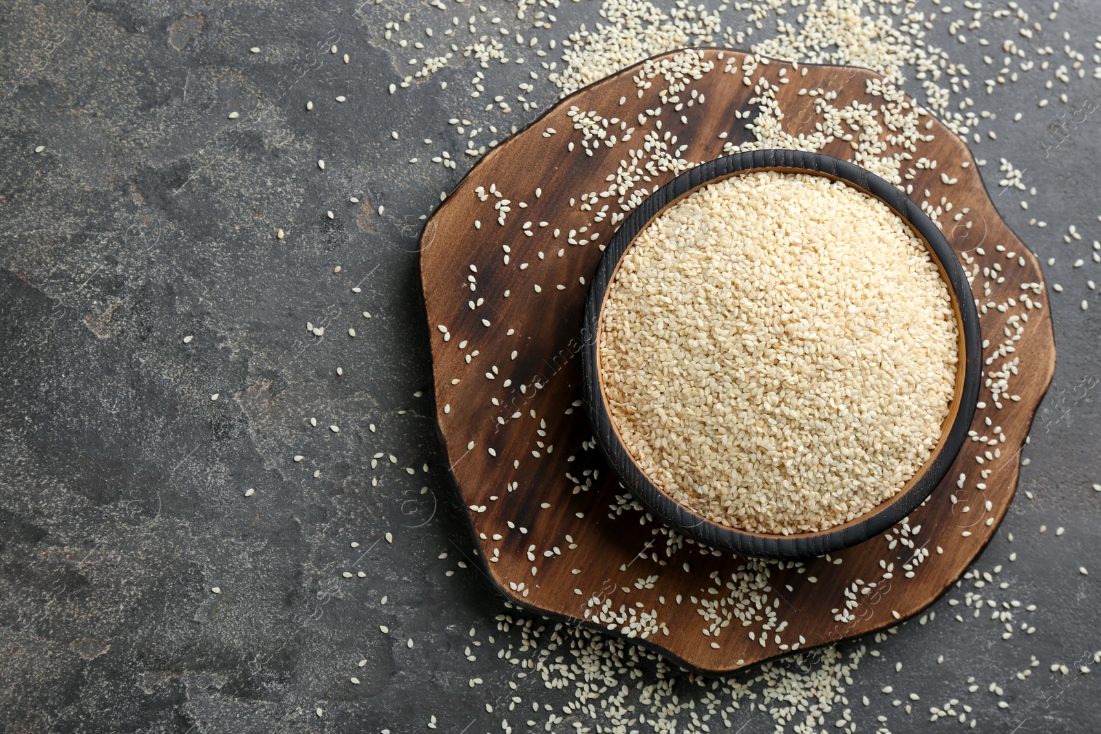 Photo of White sesame seeds on grey table, flat lay. Space for text