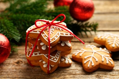 Tasty Christmas cookies with icing and festive decor on wooden table, closeup