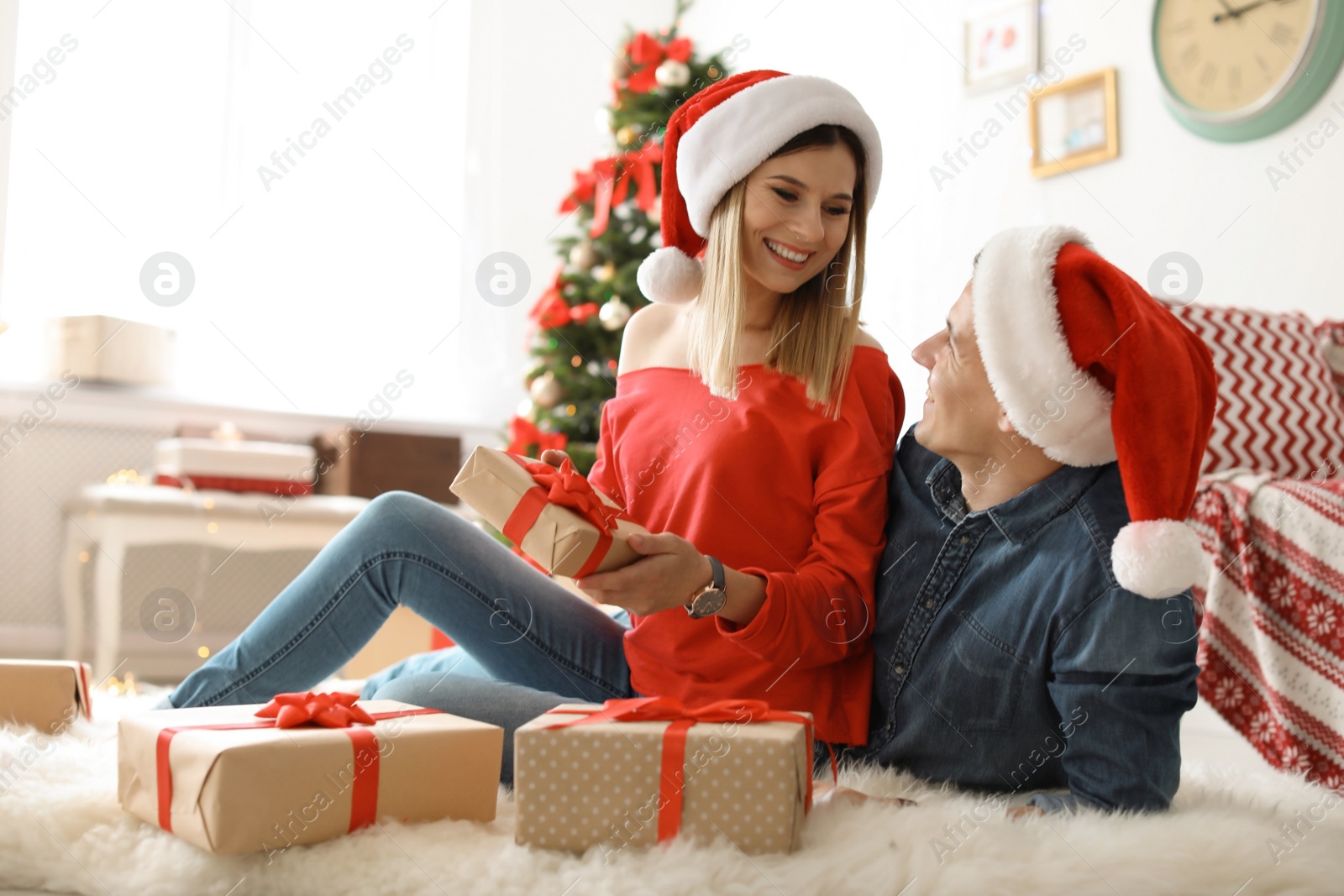 Photo of Young couple with Christmas gifts at home