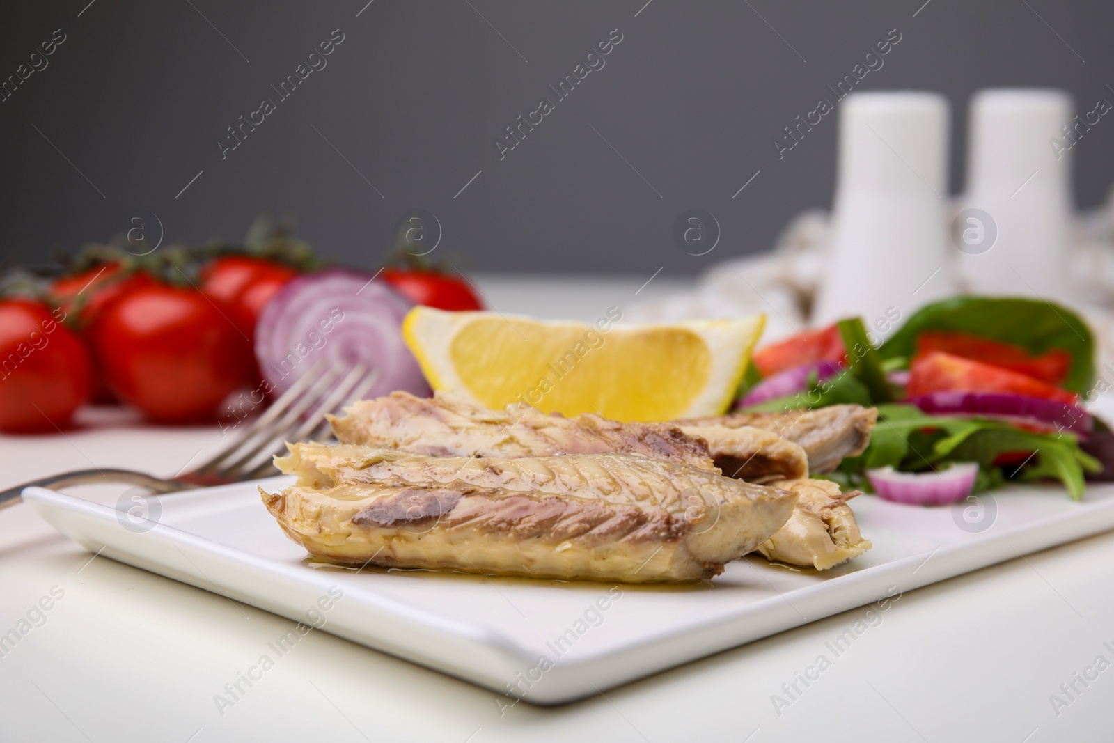 Photo of Delicious canned mackerel fillets served on white table