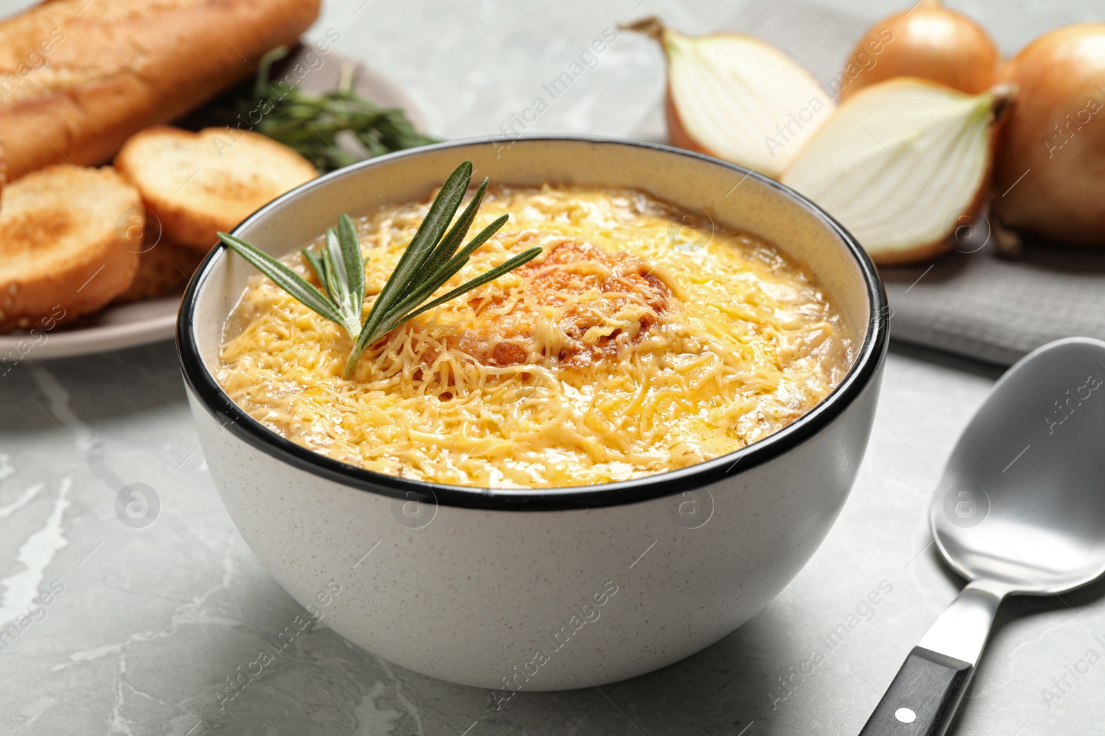 Photo of Tasty homemade french onion soup served on grey marble table