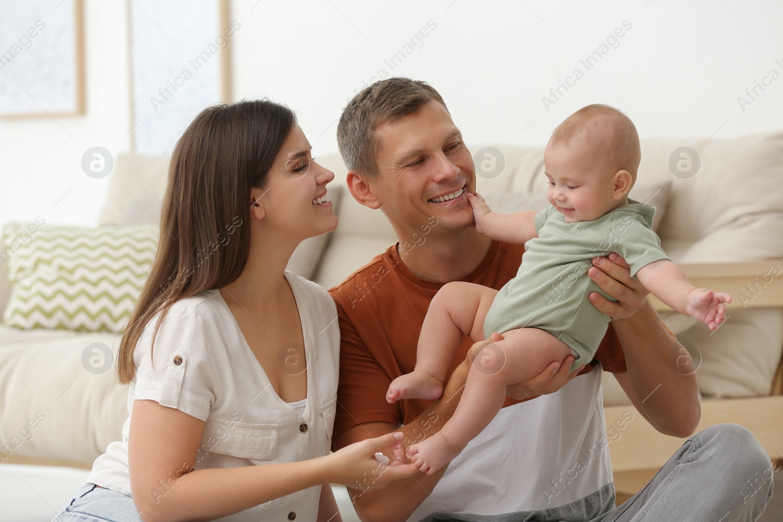 Photo of Portrait of happy family with their cute baby at home