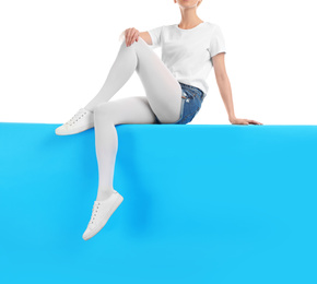 Photo of Woman wearing bright tights and stylish shoes sitting on color background, closeup