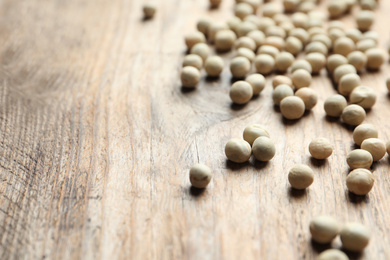 Raw dry peas on wooden background, closeup with space for text. Vegetable seeds