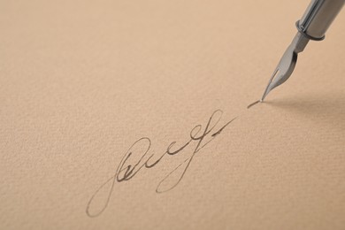 Photo of Signing on sheet of paper with fountain pen, closeup. Space for text