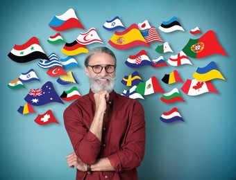 Image of Portrait of mature interpreter and flags of different countries on blue background