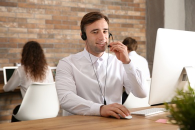 Technical support operator with headset at workplace