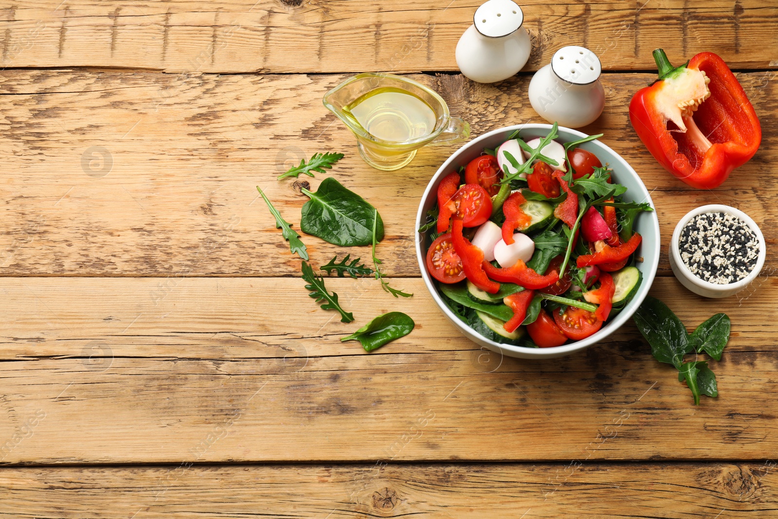 Photo of Tasty fresh vegetarian salad on wooden table, flat lay. Space for text