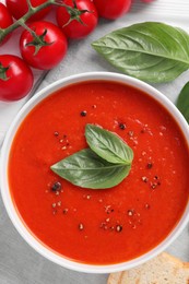 Flat lay composition with delicious tomato cream soup in bowl on table