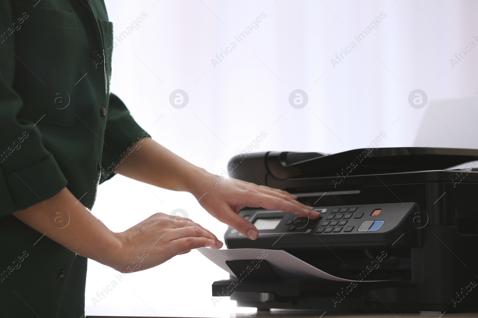 Photo of Employee using modern printer in office, closeup