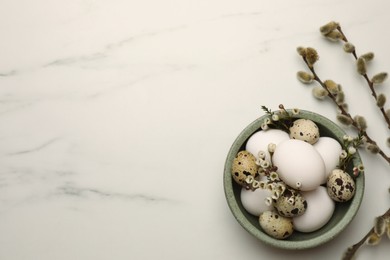 Photo of Easter eggs, flowers and pussy willow branches on white marble table, flat lay. Space for text
