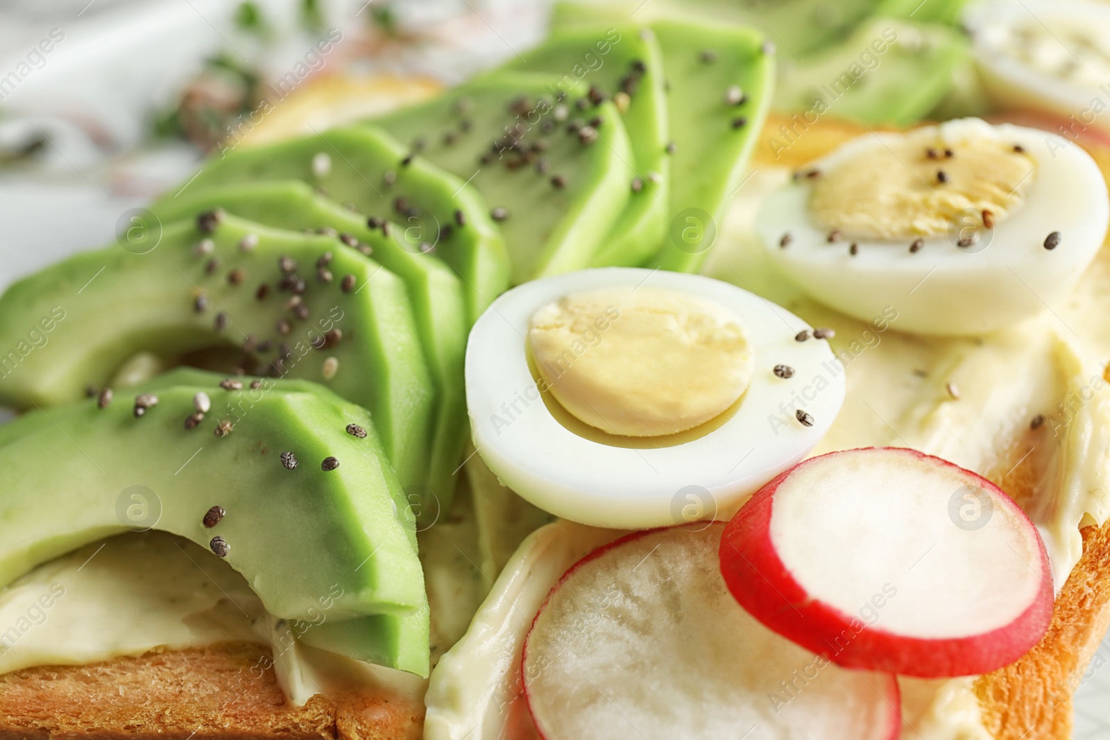 Photo of Tasty toast with avocado, quail egg and chia seeds, closeup