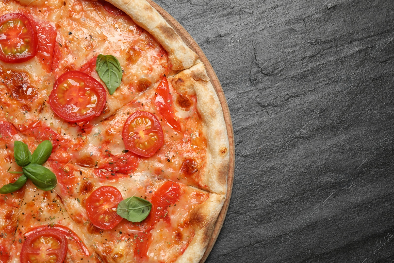 Photo of Delicious pizza Margherita on dark grey table, top view. Space for text