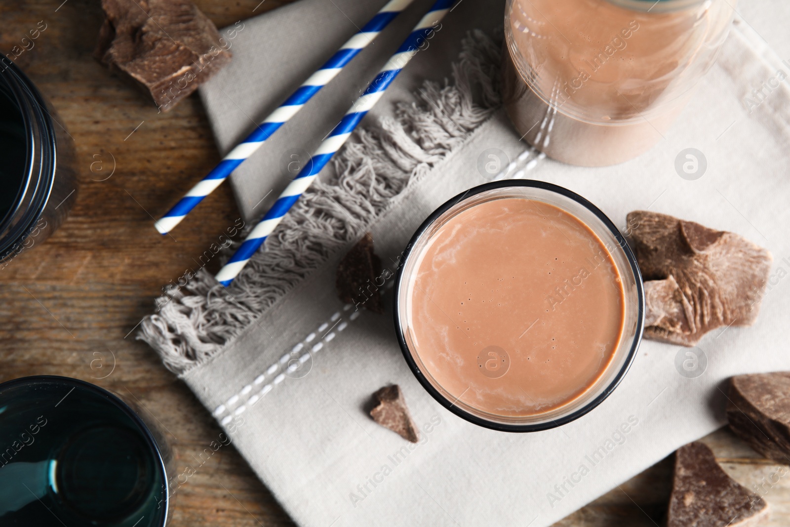 Photo of Flat lay composition with glass of tasty chocolate milk on table. Dairy drink