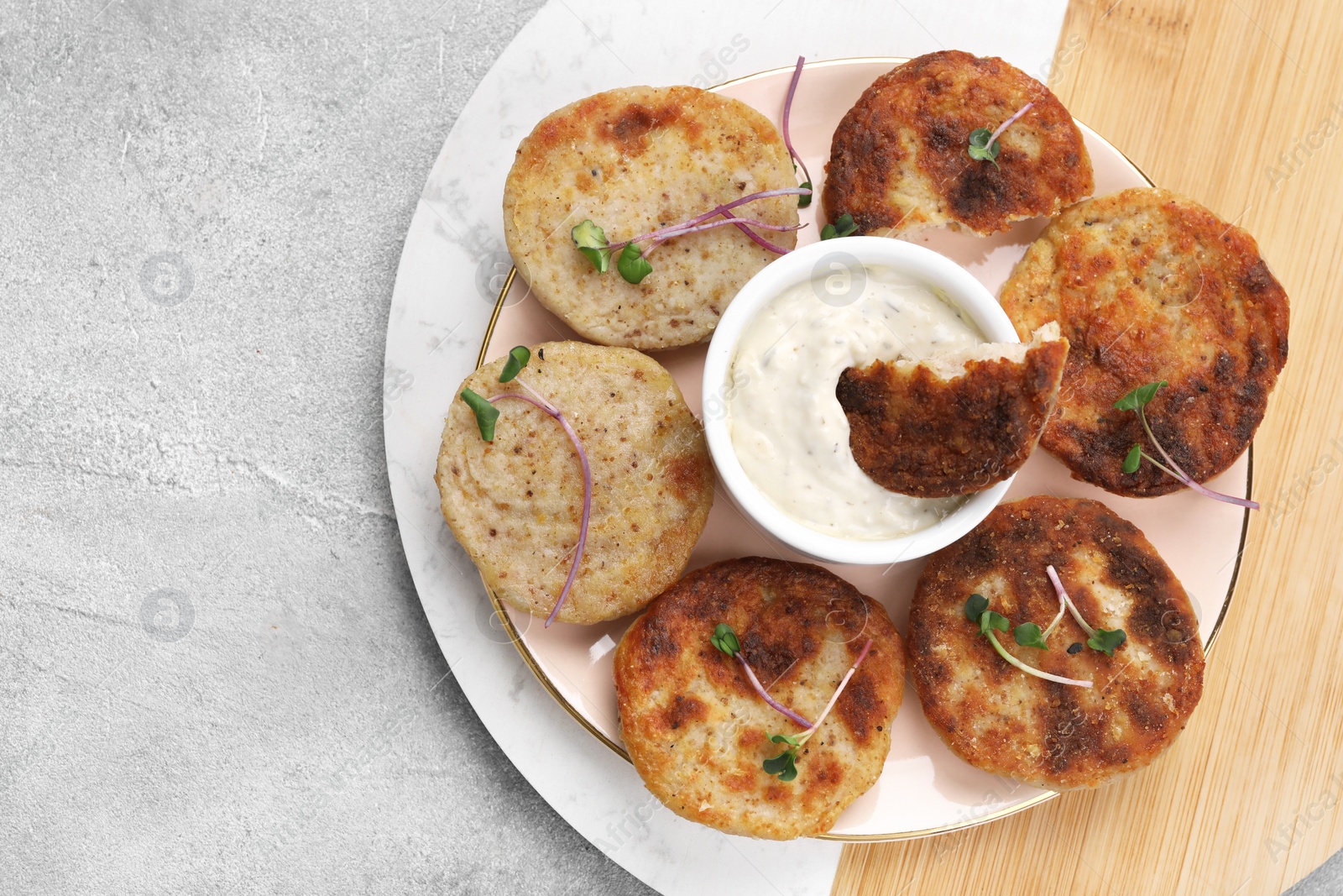 Photo of Delicious vegan cutlets and sauce on light grey table, top view. Space for text