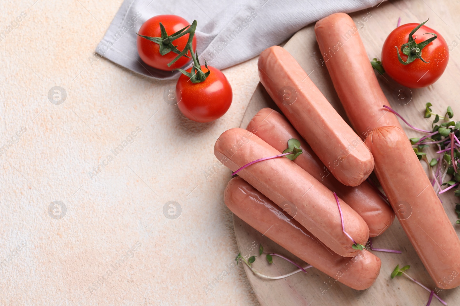 Photo of Tasty vegan sausages and products on beige table, flat lay. Space for text