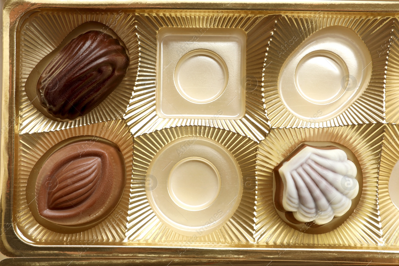 Photo of Partially empty box of chocolate candies as background, top view