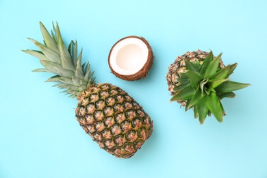 Photo of Fresh pineapples and coconut on color background