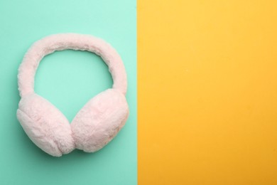 Photo of Stylish winter earmuffs on color background, top view. Space for text