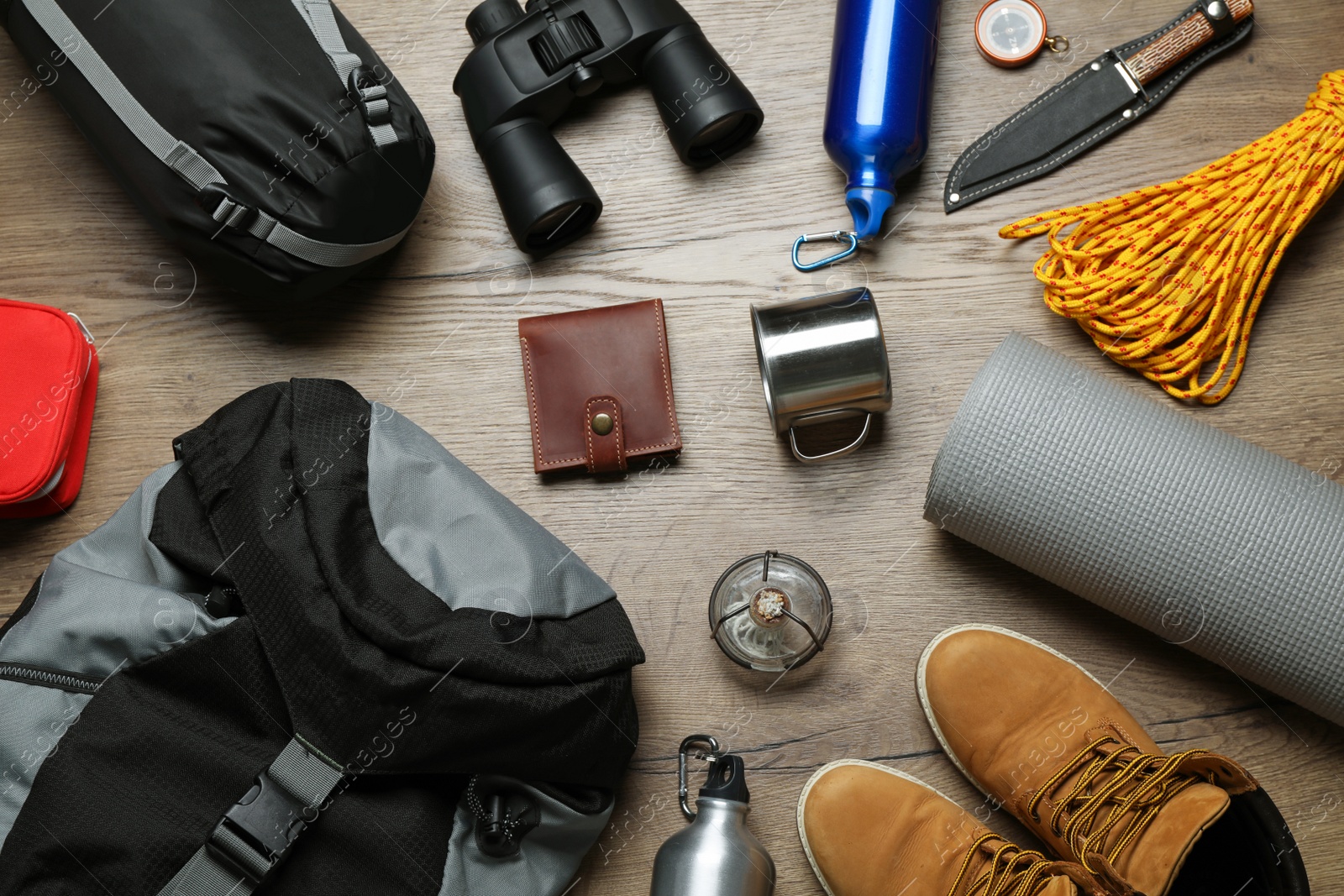 Flat lay composition with different camping equipment on wooden background Photo of Flat lay composition with different camping equipment on wooden background