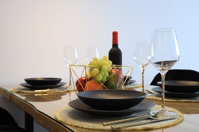 Photo of Bottle of wine and fruits on table served for dinner indoors