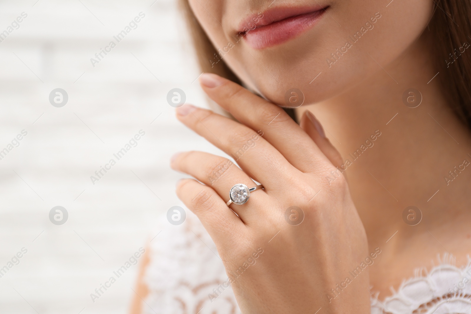 Photo of Young bride wearing beautiful engagement ring, closeup