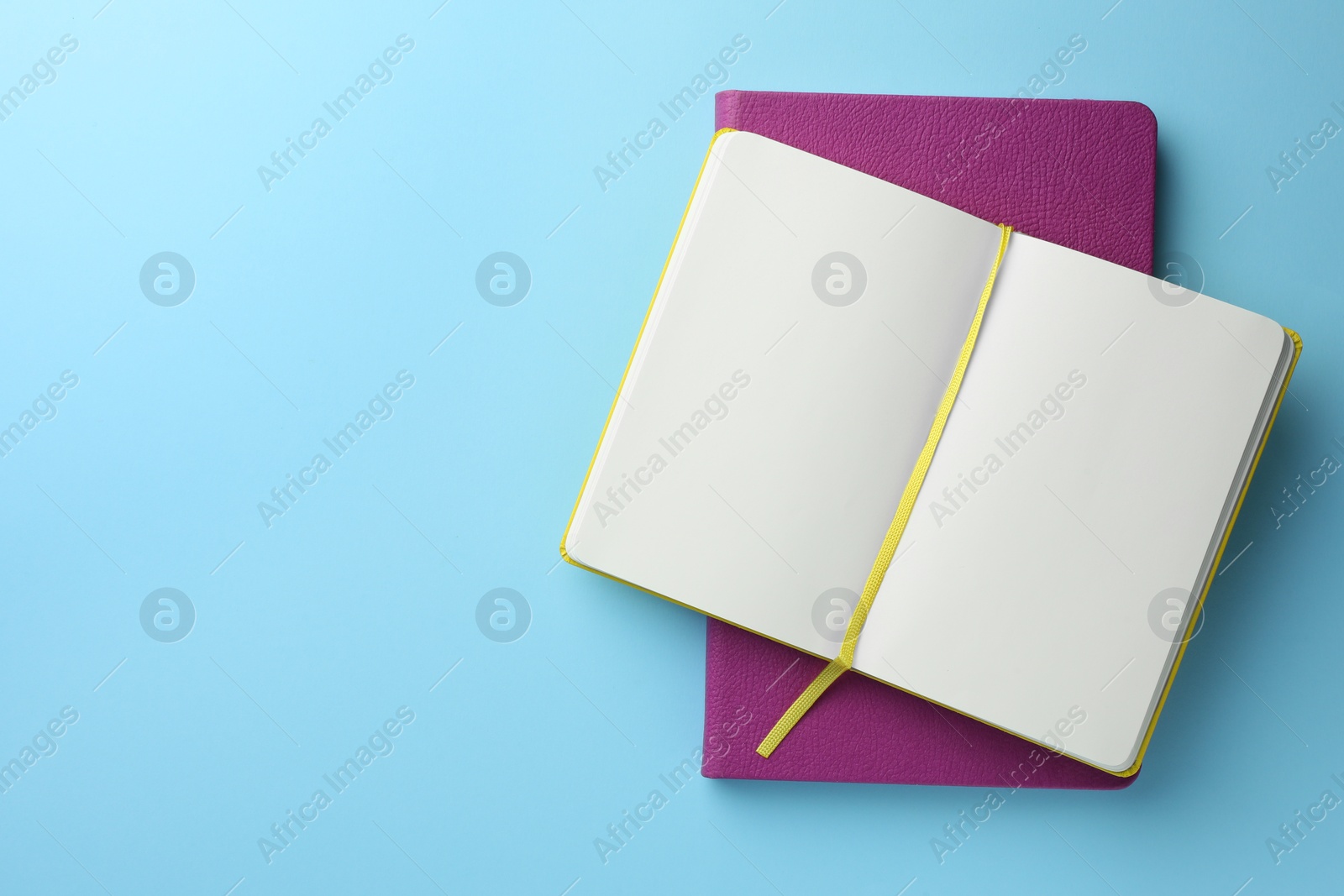 Photo of Different notebooks on light blue background, top view. Space for text